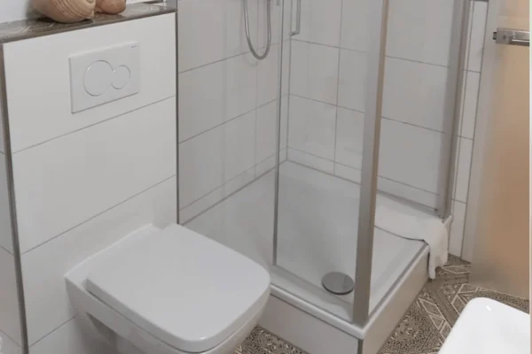 Modernes Badezimmer der Ferienwohnung Parkblick in Deidesheim mit ebenerdiger Dusche, WC und hochwertiger Ausstattung für einen komfortablen Aufenthalt.