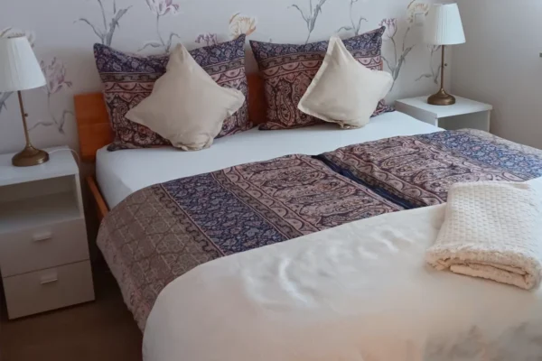 Gemütliches Schlafzimmer der Ferienwohnung Parkblick in Deidesheim mit komfortablem Doppelbett, Nachttischen und ruhiger Atmosphäre für erholsame Nächte.