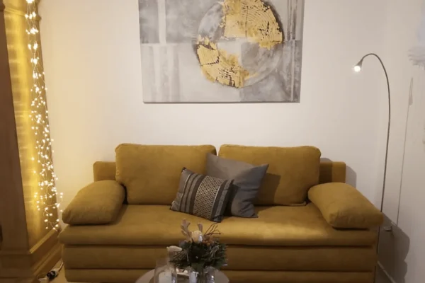 Heller und gemütlicher Wohnbereich der Ferienwohnung Parkblick in Deidesheim mit Sitzgelegenheit und moderner Einrichtung.